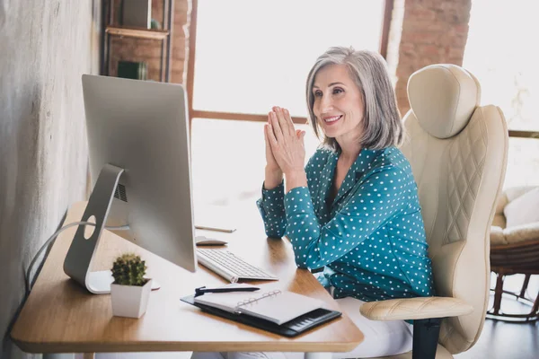 Foto van gelukkig positieve oude vrouw kijken pc scherm glimlach baas manager goed humeur zitten tafel binnen kantoor — Stockfoto