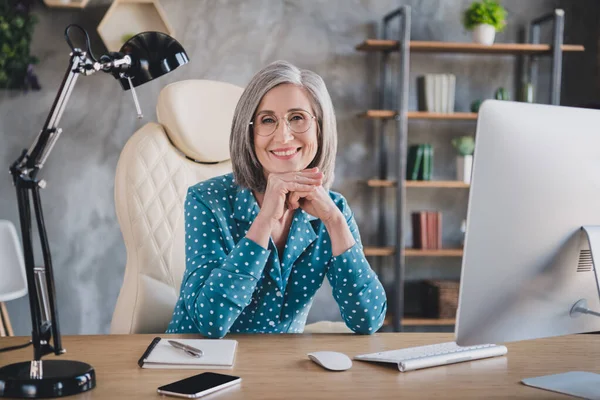 Foto van vrolijk positief gelukkig mooi oud vrouw dragen bril goed humeur kantoormedewerker binnen op de werkplek — Stockfoto
