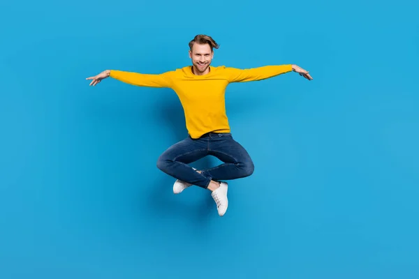 Πλήρες μέγεθος του σώματος του νεαρού άντρα πηδώντας επάνω χαρούμενο αστείο παιδιάστικο παιχνιδιάρικο απομονωμένο φωτεινό μπλε χρώμα φόντο — Φωτογραφία Αρχείου