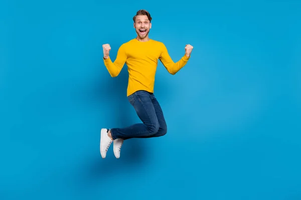 Tamanho do corpo de comprimento total de cara jovem sorrindo pulando para cima gesticulando como vencedor isolado cor azul brilhante fundo — Fotografia de Stock