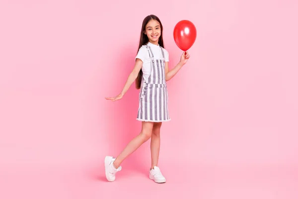 Plná délka tělo velikost fotografie školačka vedení červený vzduch balón izolované pastel růžová barva pozadí — Stock fotografie