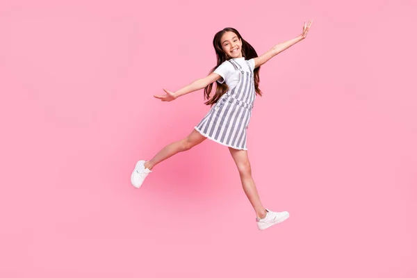 전체 몸길이 사진 학교 여학생 이 장난기없는 고립된 파스텔 핑크 색 배경을 점프 — 스톡 사진