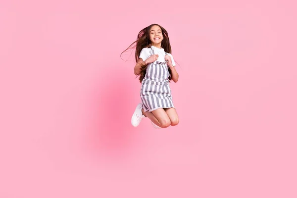 활동적 인 펑키 행복 한 어린 소녀의 전신 사진 파스텔 핑크 색 배경에 고립된 긍정적 인 공기 미소 위로 점프 — 스톡 사진