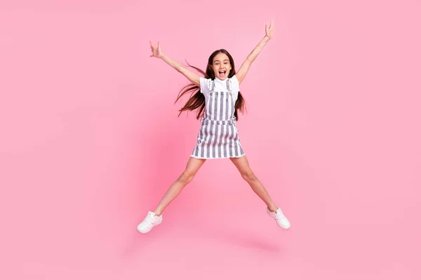Plná délka fotografie veselá šťastná holčička vyskočit do vzduchu hvězda tvar dobré nálady izolované na růžové barvy pozadí — Stock fotografie