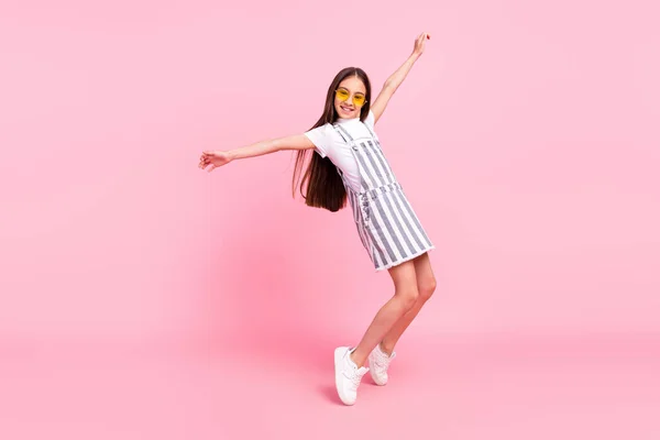Full längd kropp storlek foto skolflicka i övergripande glasögon dans i casual kläder isolerad pastell rosa färg bakgrund — Stockfoto