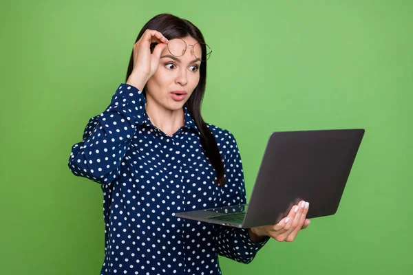 深褐色头发的照片年轻女士手持笔记本电脑，戴着蓝色眼镜，背景为绿色 — 图库照片