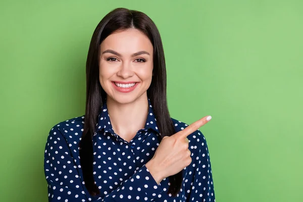 Foto de promotor niña dedo directo espacio vacío sonrisa dentada usar blusa punteada aislado en fondo de color verde — Foto de Stock