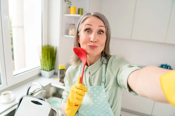 Автопортрет привабливої веселої сіро-волохатої жінки, яка робить прибирання посуду, отримуючи задоволення від гарного настрою вдома світло-білого в приміщенні — стокове фото