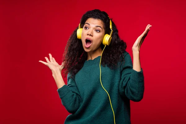 Foto van aantrekkelijke mooie funky afro-Amerikaanse jonge vrouw luisteren muziek headset zingen geïsoleerd op rode kleur achtergrond — Stockfoto