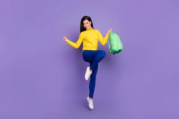 Foto in voller Größe von attraktiven jungen Frau springen Gewinner halten Rucksack isoliert auf lila Hintergrund — Stockfoto