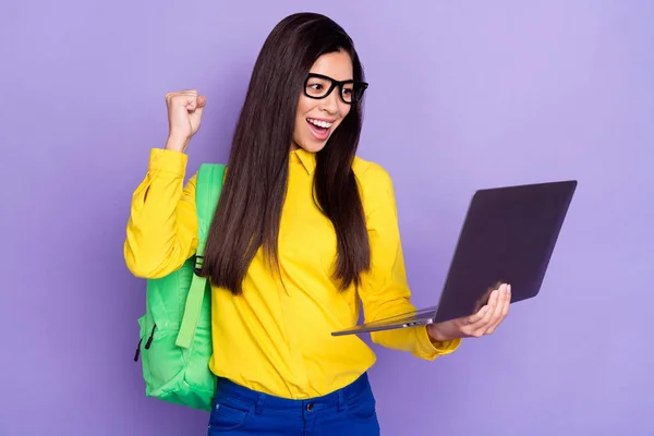 Fénykép vidám szép fiatal nő néz laptop emelje ököl kopás szemüveg mosoly elszigetelt lila színű háttér — Stock Fotó