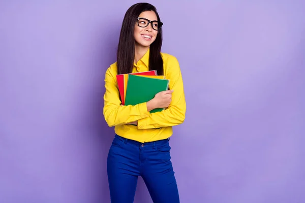 Foto de sonho jovem atraente senhora feliz olhar espaço vazio segurar mãos livros didáticos isolados em fundo cor violeta — Fotografia de Stock