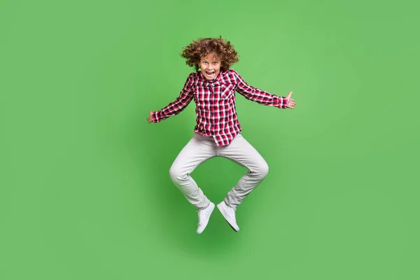 밝은 녹색 배경 위로 떨어져 점프하는 잘생긴 쾌활 한 남자의 전체 몸길이 전망 — 스톡 사진