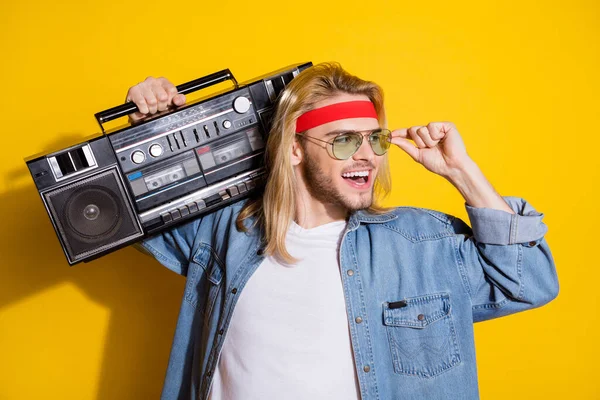 Photo of cool sweet gentleman wear jeans shirt arm glasses listening boombox looking empty space smiling isolated yellow color background — Stock Photo, Image