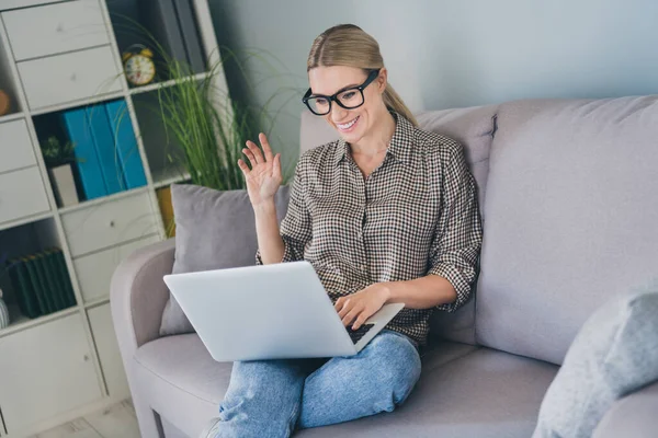 Фото уверенной исполнительной леди босса сидеть диван использовать приложение ноутбук говорить Привет коллеги в доме в помещении — стоковое фото