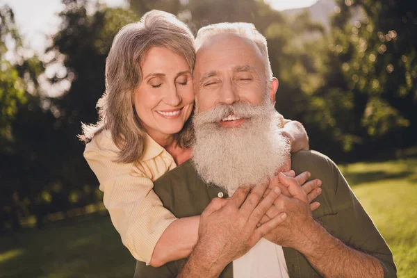 Foto de gente feliz de pelo gris positiva pareja abrazar vacaciones de primavera al aire libre en el parque — Foto de Stock