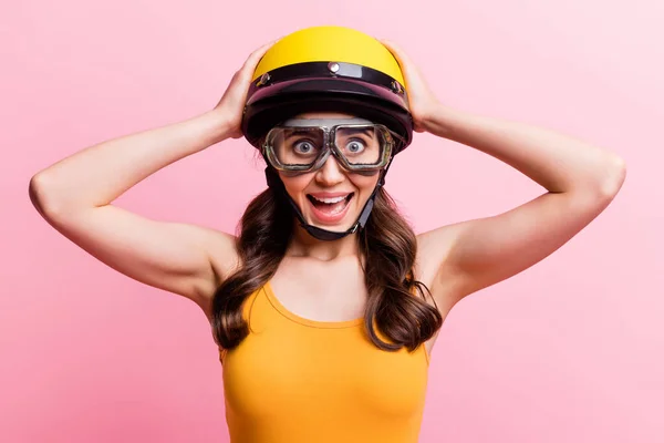 Foto van hoera sportvrouw dame dragen oranje top brillen touch helm geïsoleerd op roze achtergrond — Stockfoto