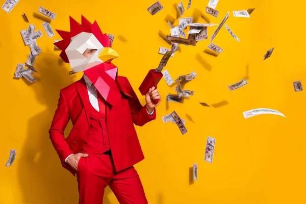 Photo of confident millionaire guy hold pistol shoot usd banknotes wear cock mask red suit isolated yellow color background — Stock Photo, Image