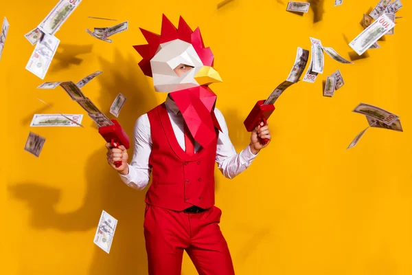 Photo of weird guy hold money gun spend million usd wear cock polygonal mask red suit isolated yellow color background — Stock Photo, Image