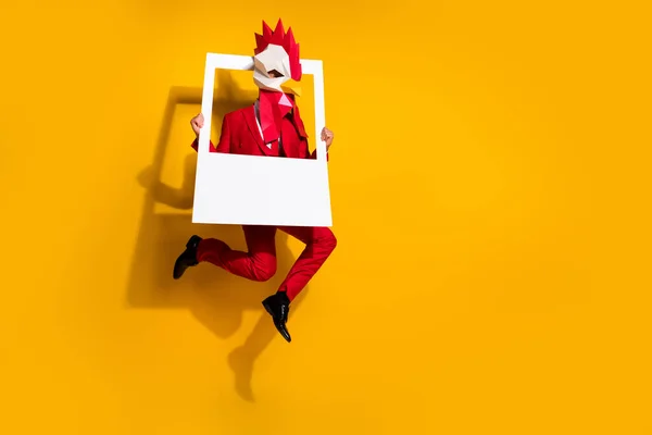 Foto do cara salto segurar quadro instantâneo fazer imagem desgaste galo máscara poligonal vermelho smoking isolado cor amarela fundo — Fotografia de Stock