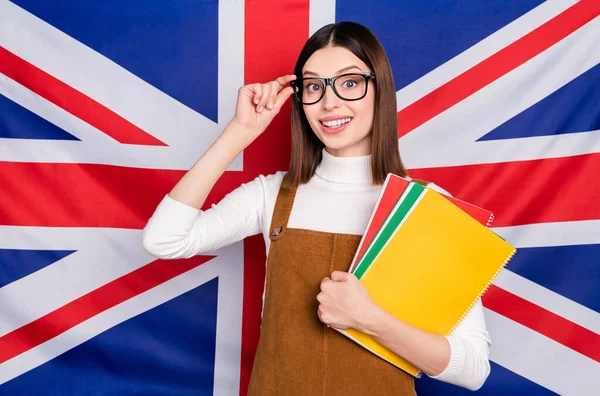 Foto de chica encantadora joven mantenga el programa internacional ciudadano material aislado sobre el fondo de la bandera del Reino Unido —  Fotos de Stock