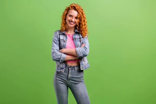 Foto di bella fiduciosa giovane donna indossare jeans vestito occhiali braccia incrociate spazio vuoto sorridente isolato colore verde sfondo — Foto Stock