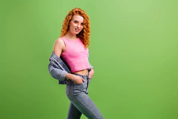 Foto de encantador muito jovem mulher usar jeans roupa óculos braços bolso espaço vazio sorrindo isolado cor verde fundo — Fotografia de Stock