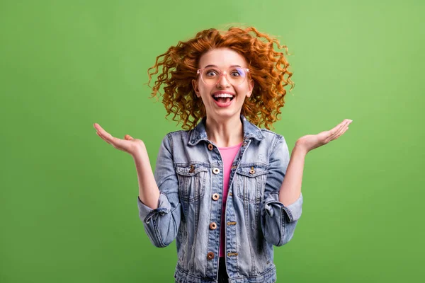 Fotografie legrační šokované mladé ženy nosit džíny outfit brýle rostoucí paže s úsměvem izolované zelené barvy pozadí — Stock fotografie