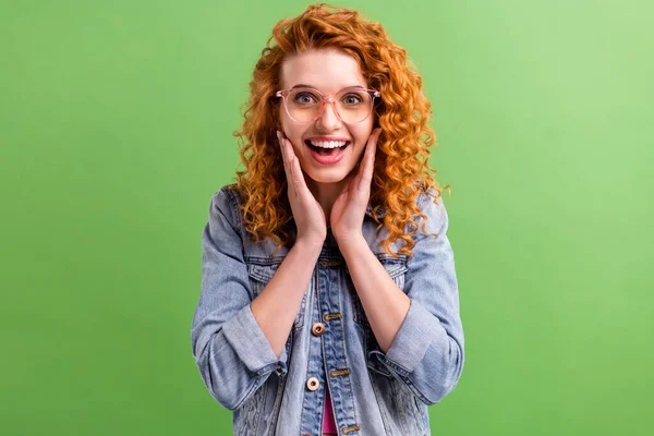 Fotografie mladé dívky šťastný pozitivní úsměv ruce dotek tváře ohromený šok izolované přes zelenou barvu pozadí — Stock fotografie