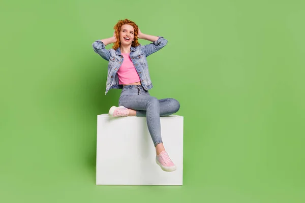 Foto de longitud completa de la joven feliz sonrisa positiva mano toque jengibre pelo ondulado aislado sobre fondo de color verde — Foto de Stock