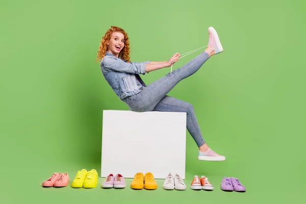 Pleine longueur profil côté photo de jeune fille heureux sourire positif magasin ajustement chaussures lacets client isolé sur fond de couleur verte — Photo
