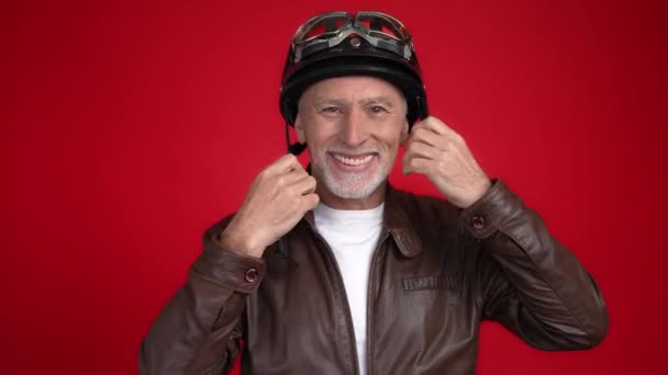 Wiek motocyklista test fit kask pokazać kciuk do góry znak pojedynczy szkarłat kolor tła — Wideo stockowe