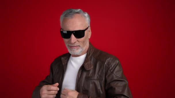 Middle aged man ready disco touch specs isolated scarlet color background — Stock Video