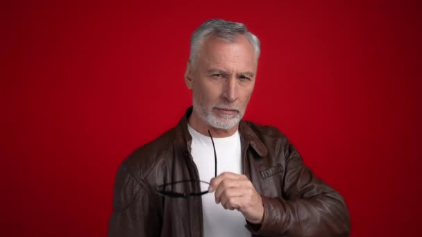 Дорослий чоловік торкається підборіддя ручний салон лосьйон ізольований червоний колір фону — стокове відео