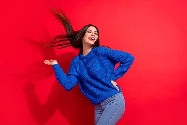 Foto de encantadora joven dama volar pelo peinado agarre la cintura de la mano buen humor aislado en el fondo de color rojo —  Fotos de Stock