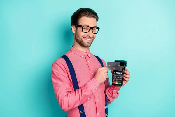 Foto van leuke aantrekkelijke jonge man gekleed roze shirt bril betalen terminal credit card geïsoleerde turquoise kleur achtergrond — Stockfoto