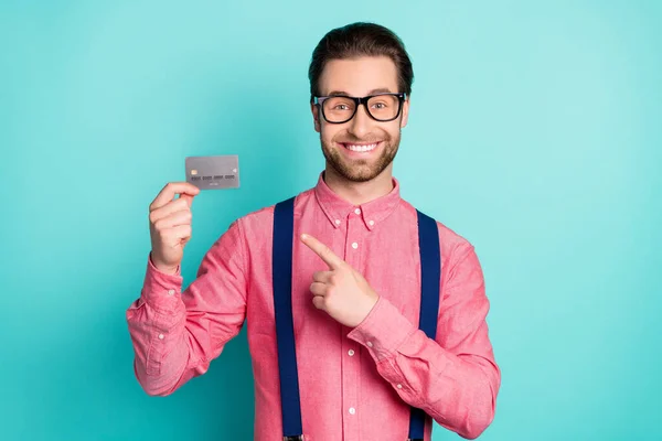 Foto van jongeman gelukkig positieve glimlach punt vinger credit card adviseren ad geïsoleerd over teal kleur achtergrond — Stockfoto