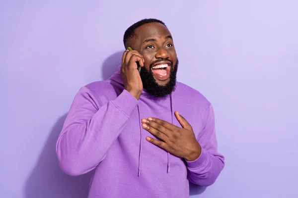 Portret van aantrekkelijke trendy vrolijke man praten op de telefoon lachen grappig verhaal geïsoleerd op paarse kleur achtergrond — Stockfoto