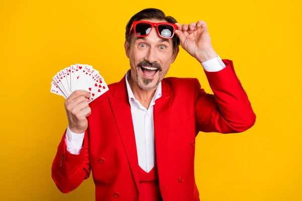 Photo de joueur de poker étonné en costume rouge de luxe à la mode gagner beaucoup de succès d'argent isolé sur fond de couleur jaune — Photo