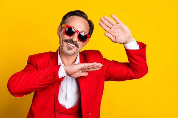 Retrato de hombre de buena apariencia de mediana edad bailando tonteando alrededor de usar traje rojo aislado en el fondo de color amarillo — Foto de Stock