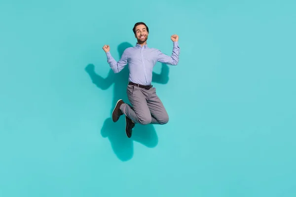 Foto de surpreendido campeão gerente saltar levantar punhos desgaste camisa violeta isolado turquesa cor de fundo — Fotografia de Stock