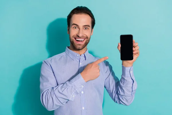 Foto van opgewonden man geven wijsvinger telefoon scherm lege ruimte dragen violet shirt geïsoleerde teal kleur achtergrond — Stockfoto
