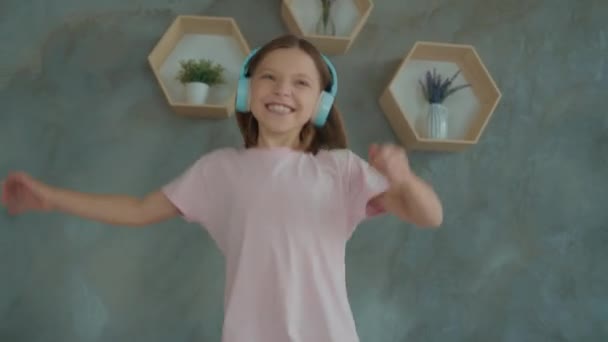 Školačka tanec gauč poslouchat headset sen hráč rock jeviště v bytě — Stock video