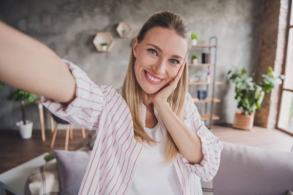 Fotografie dospělé hezké ženy, aby selfie rameno dotek tváře obývací pokoj self-izolace karanténa uvnitř — Stock fotografie