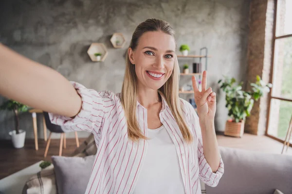 Foto van mooie volwassen blonde dame doen selfie show v-teken dragen witte shirt alleen thuis — Stockfoto