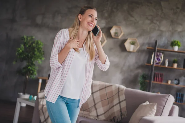 Foto di fresco giovane signora bionda sentire telefono look usura camicia a righe a casa in soggiorno week-end vacanza da solo — Foto Stock