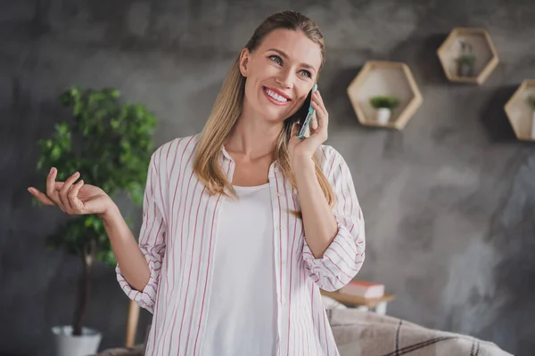 Fotografie optimistické mladé blond dáma mluvit telefon nosit bílou košili doma v obývacím pokoji sám — Stock fotografie