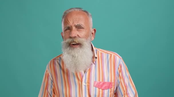 Hombre de mediana edad problemas de salud del oído sordera aislado fondo de color cian — Vídeo de stock