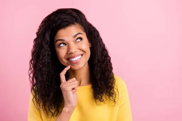 Foto de jovem alegre menina negra olhar curioso espaço vazio toque dedo queixo isolado sobre cor rosa fundo — Fotografia de Stock