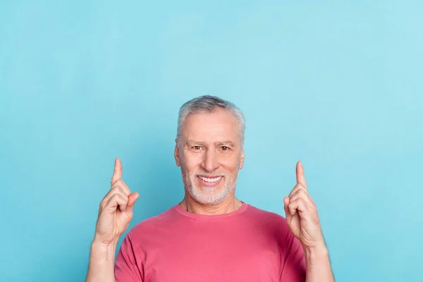 Retrato de atractivo hombre de pelo gris alegre demostrando hasta espacio de copia anuncio decisión aislado sobre fondo de color azul brillante — Foto de Stock